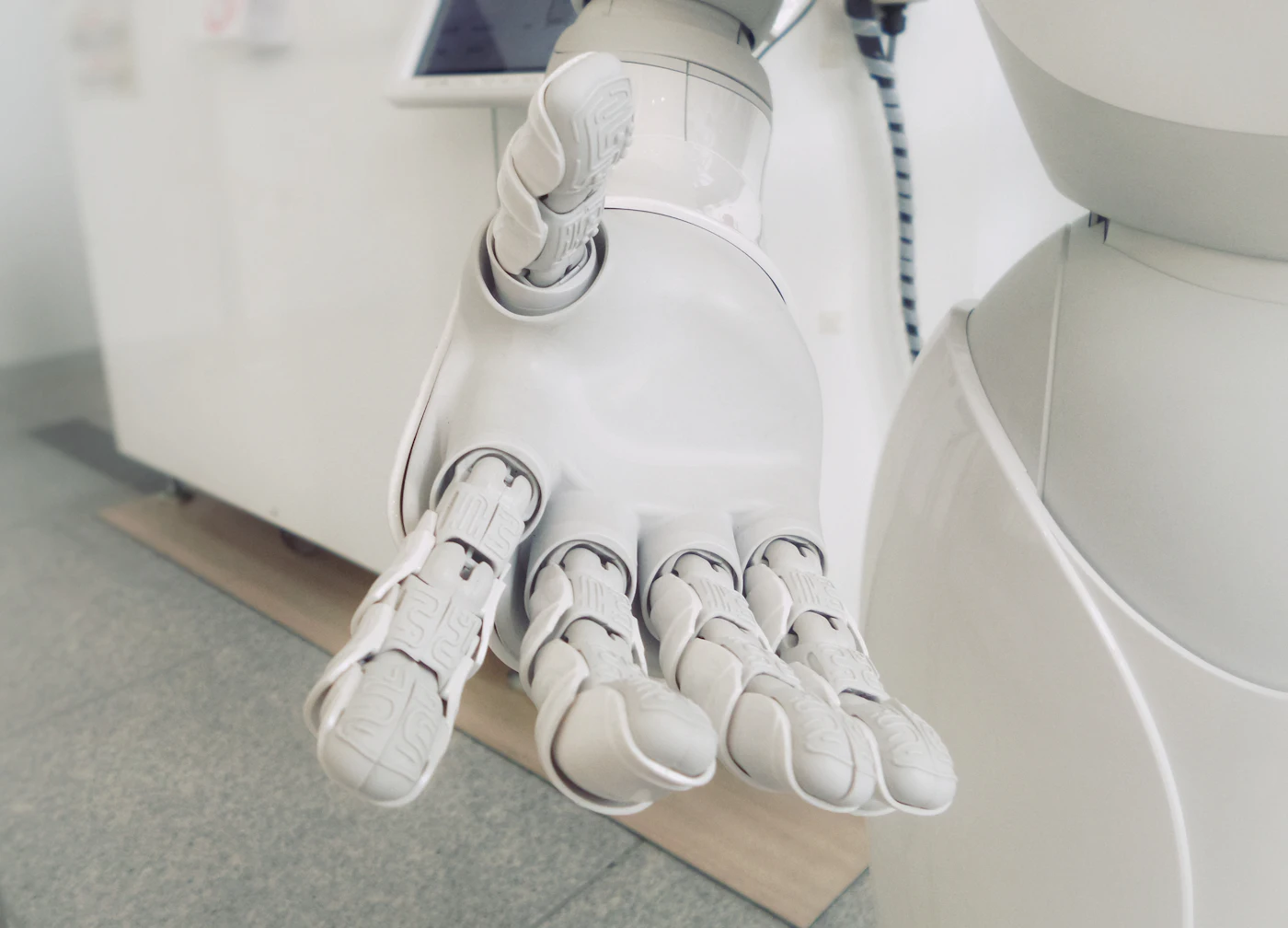 Close-up of a white robotic hand with articulated fingers reaching forward